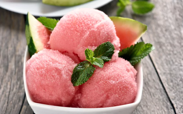 A 4K Ultra HD PC desktop wallpaper featuring three scoops of pink watermelon ice cream garnished with mint leaves and watermelon slices in a white bowl.