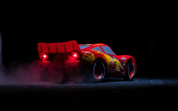 HD desktop wallpaper featuring Lightning McQueen from Cars 3, showcasing a dramatic rear view with red taillights glowing in the dark.