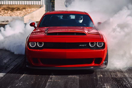 HD wallpaper of a red Dodge Challenger SRT Demon muscle car performing a burnout, showcasing the iconic Mopar vehicle’s power and aggressive design.
