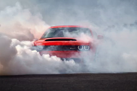 A red Dodge Challenger SRT Demon performs a burnout, enveloped in thick smoke against a gray backdrop. The sleek muscle car showcases power and aggression, captured in high definition.