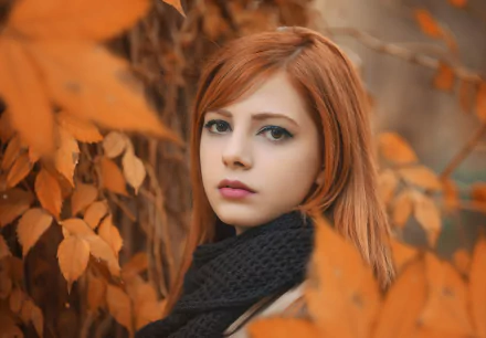 HD desktop wallpaper of a redhead woman with brown eyes, wearing a black scarf, surrounded by vibrant fall foliage.