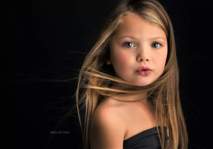 HD desktop wallpaper featuring a close-up portrait of a cute little girl with flowing hair against a black background, highlighting her expressive face in child photography.