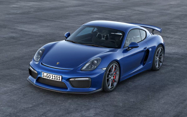 HD desktop wallpaper showcasing a sleek blue Porsche Cayman GT4 parked on a gray surface, highlighting its sporty design and iconic vehicle features.