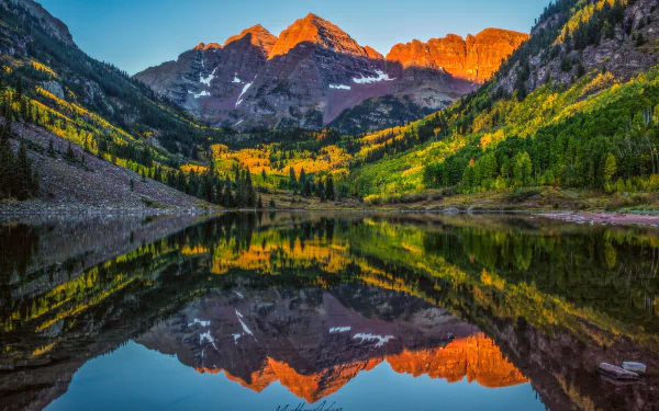 HD desktop wallpaper of Maroon Bells in the Elk Mountains of Colorado, showcasing a stunning reflection of peaks and vibrant nature in a tranquil lake.
