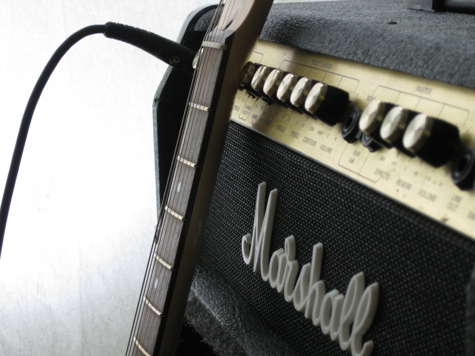 A close-up of a guitar neck connected to a Marshall amplifier, capturing the essence of music in a striking HD wallpaper for desktop backgrounds.