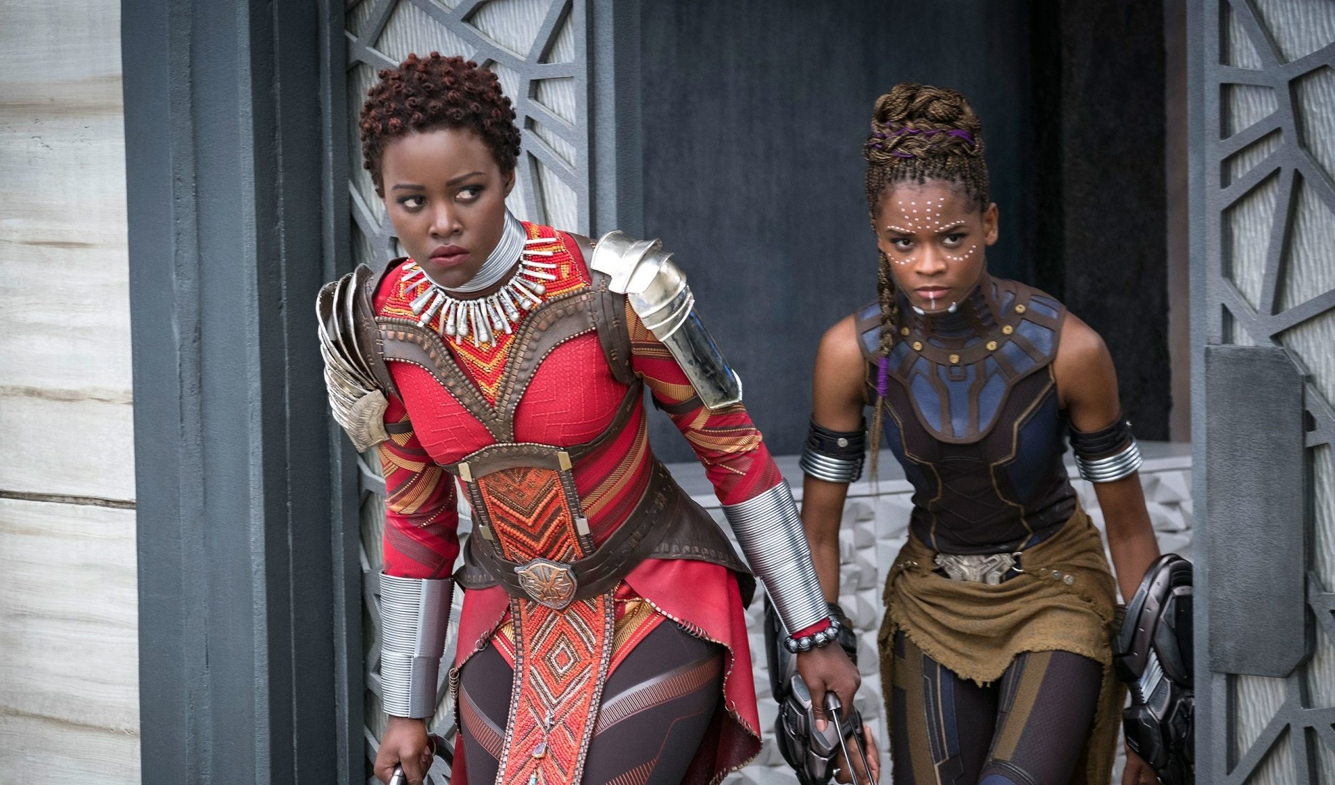 Two characters from the movie Black Panther in action, dressed in detailed, colorful costumes. The image is a high-definition desktop wallpaper and background.