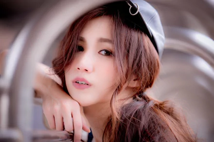 HD desktop wallpaper featuring a brunette Asian woman with brown eyes and a contemplative expression. Her face is framed by soft lighting, enhancing her natural beauty.