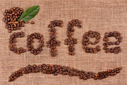4K Ultra HD PC desktop wallpaper featuring the word coffee spelled out with coffee beans on a textured burlap background, accented by a green leaf and scattered beans.