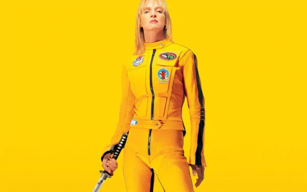 A striking HD wallpaper featuring the character Beatrix Kiddo from Kill Bill: Vol. 1, dressed in a yellow jumpsuit and wielding a katana against a vibrant yellow background.