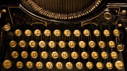 Close-up HD desktop wallpaper of a vintage man-made typewriter keyboard with round, yellowed keys and a classic QWERTY layout.