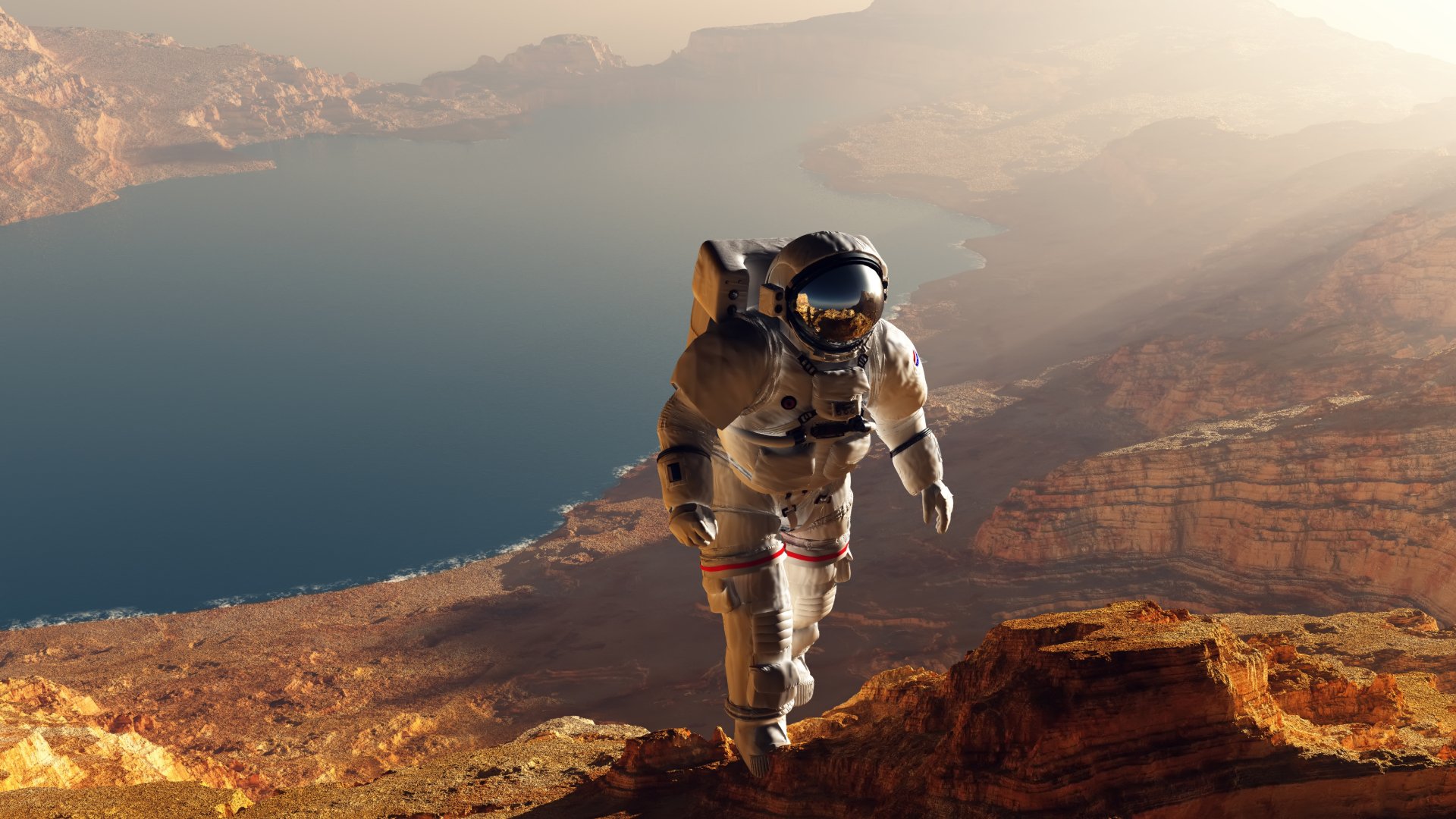 Sci-fi astronaut climbs a red rocky canyon beside a vast alien lake at sunset — 2K Quad HD PC desktop wallpaper and background.