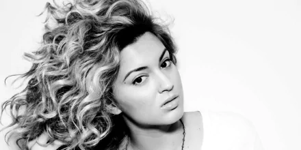 HD desktop wallpaper and background featuring a black and white portrait of Tori Kelly with voluminous curly hair.