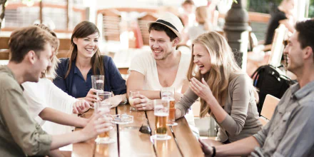 HD desktop wallpaper of a group of friends enjoying drinks and conversation at a table.