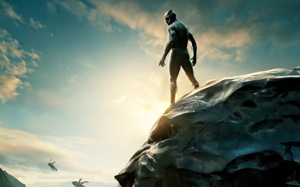 Black Panther stands on a rocky cliff with a stunning sunset in the background. The image is a HD desktop wallpaper and background, capturing the iconic character against a dramatic sky.