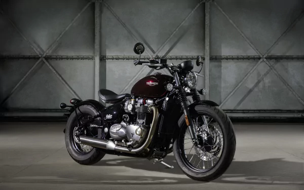 A sleek Triumph Bonneville motorcycle showcased against a textured industrial backdrop, captured in stunning 4K Ultra HD for PC desktop use.