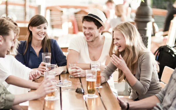 HD desktop wallpaper of a group of friends enjoying drinks and conversation at a table.