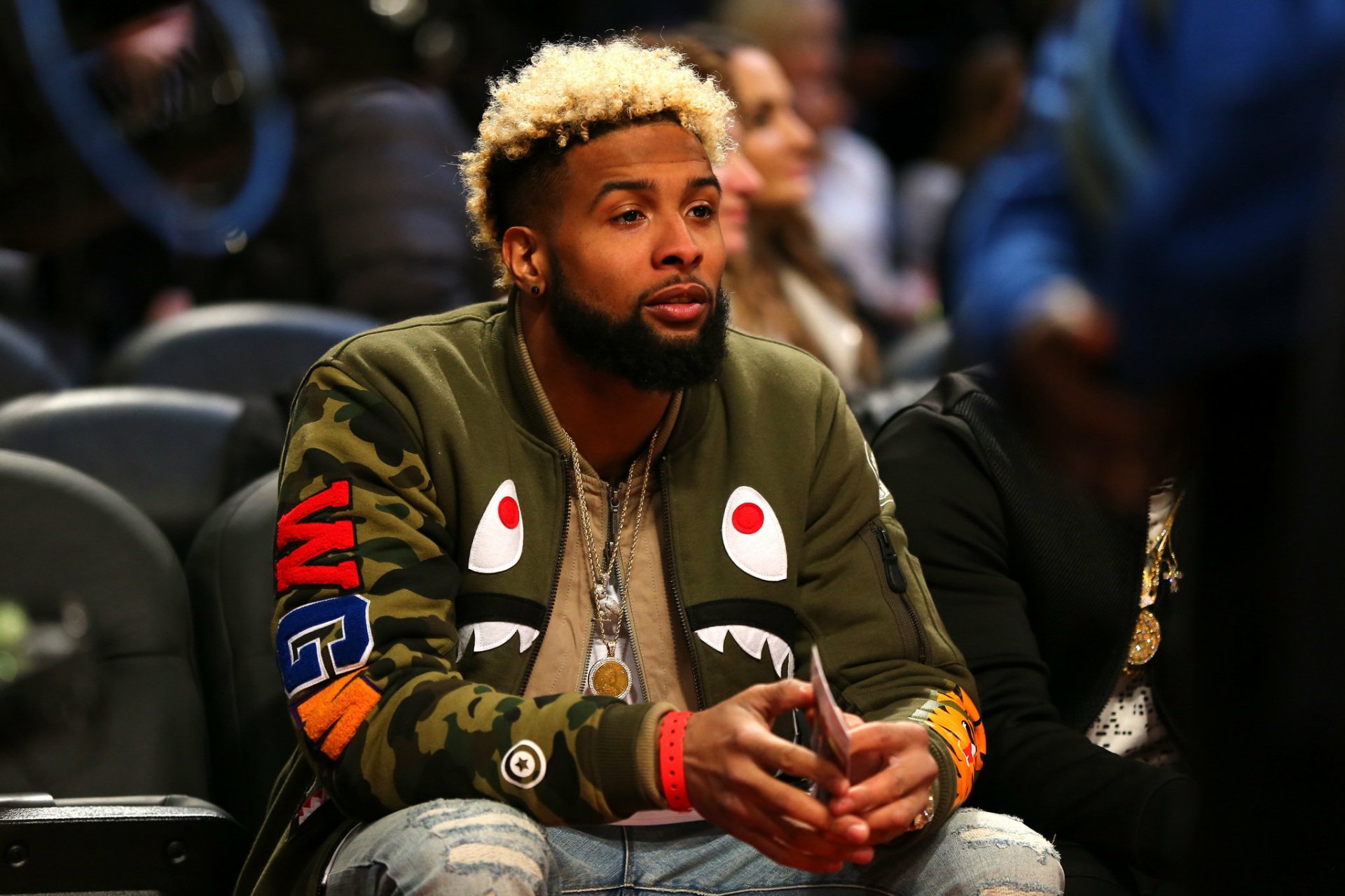 HD desktop wallpaper featuring a person associated with the New York Giants, sitting courtside in a stylish outfit.