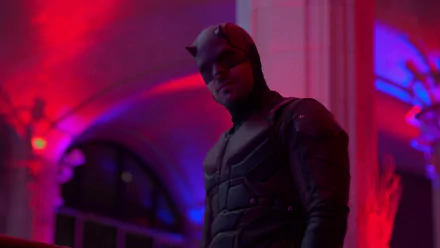 Daredevil from The Defenders TV show standing in a red-purple lit corridor — 2K Quad HD PC desktop wallpaper/background featuring the masked hero in a shadowed suit.