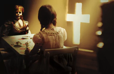 4K Ultra HD PC desktop wallpaper featuring a scene from the movie Annabelle: Creation, showing a creepy doll and a girl at a table with a glowing cross in the background.