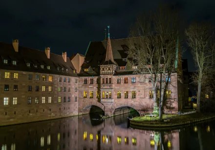 Night view of a historic German building housing a restaurant, illuminated and reflecting on the calm water, captured in 4K Ultra HD for a PC desktop wallpaper.