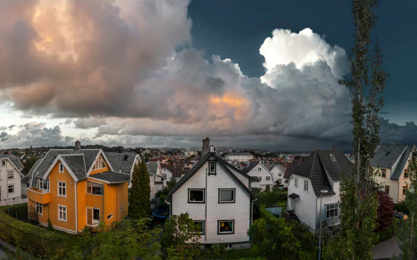 A vibrant Finnish town with colorful houses under dramatic clouds, captured in stunning 4K Ultra HD for a vivid PC desktop wallpaper and background.