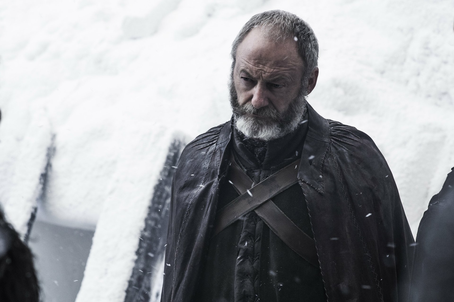 Somber actor portraying Davos Seaworth from Game of Thrones in a snow-dusted cloak — moody 4K Ultra HD PC desktop wallpaper/background.