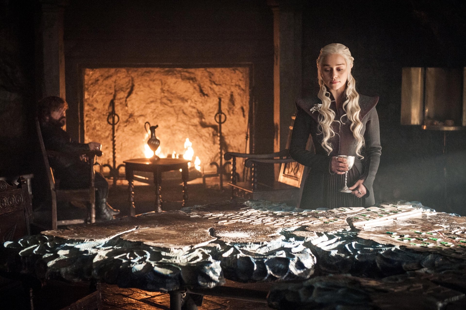 Game of Thrones 4K Ultra HD PC desktop wallpaper/background: dim war room scene with a silver‑haired woman standing at a map table and a man seated by a roaring fireplace.