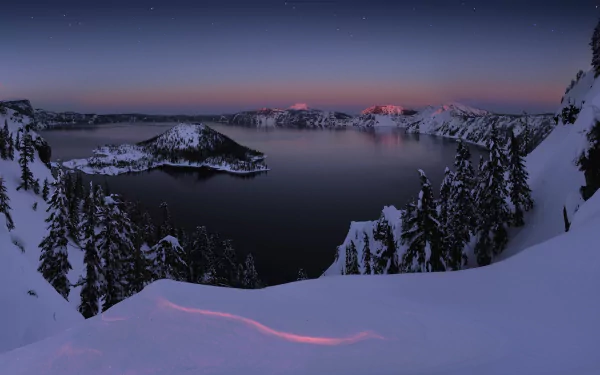 Winter night scene of snow-covered trees overlooking Crater Lake, captured in HD as a serene nature wallpaper background.
