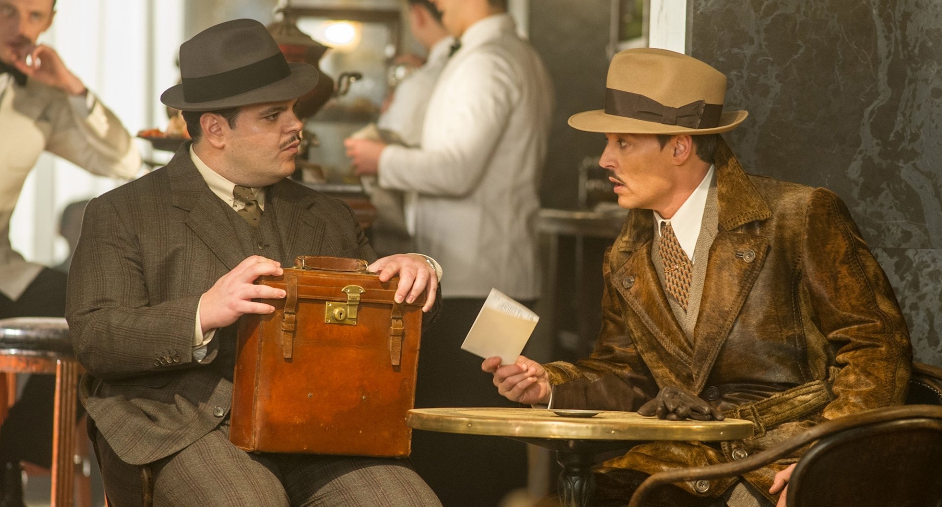 HD desktop wallpaper from the movie Murder on the Orient Express (2017), featuring characters portrayed by Johnny Depp and Josh Gad engaged in a conversation.