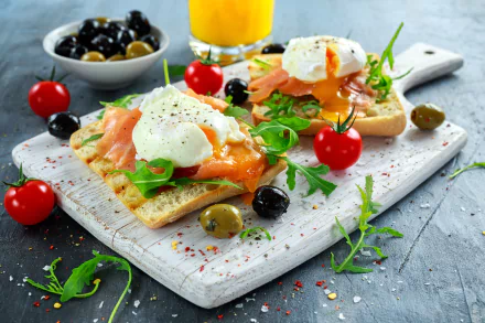 Still life of smoked salmon and poached eggs on toast with olives and cherry tomatoes, garnished with arugula — 5K Ultra HD PC desktop wallpaper and food background.