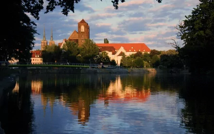 A serene lake reflects a picturesque building and vibrant sky during sunset, creating a stunning composition for HD desktop wallpaper and background.