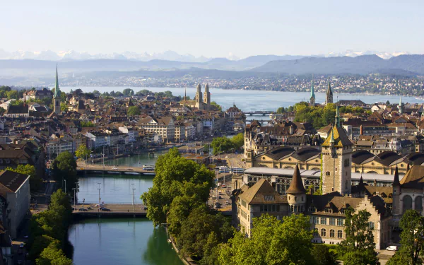A stunning view of Zurich, Switzerland, showcasing its vibrant cityscape along the river and lake, with historic buildings and lush greenery in a bright, clear atmosphere.