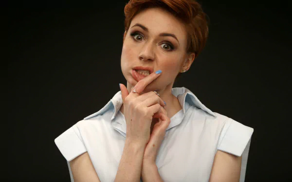Close-up studio portrait of a short-haired redhead woman with a thoughtful expression against a dark background, 5K Ultra HD PC desktop wallpaper.