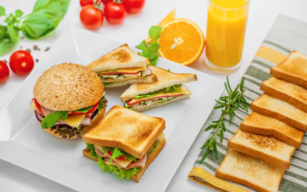 HD desktop wallpaper featuring a still life of sandwiches, a burger, toast, and a glass of orange juice, artfully arranged on a white surface with fresh ingredients.