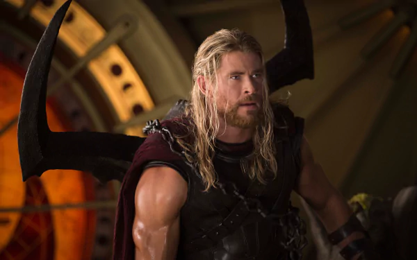 HD desktop wallpaper featuring Chris Hemsworth as Thor from the movie Thor: Ragnarok. Thor is in full armor, holding a weapon, set against a dramatic background.