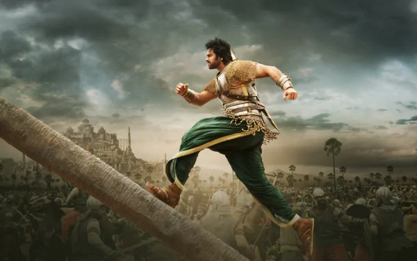 A dynamic HD desktop wallpaper from the movie Baahubali 2: The Conclusion, featuring a warrior running up a wooden structure with a castle and battlefield in the background.