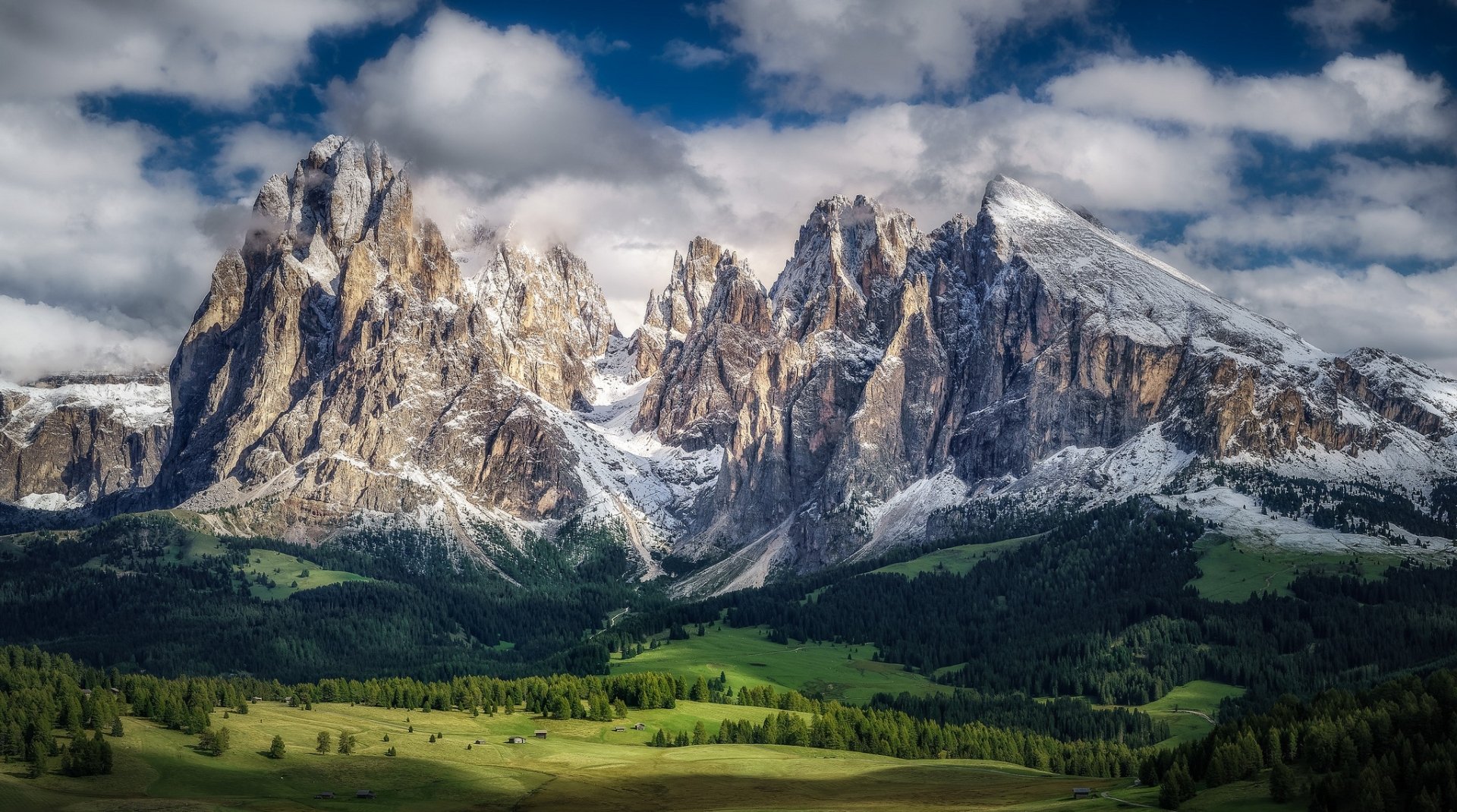 HD landscape wallpaper featuring a majestic mountain peak under a partly cloudy sky, surrounded by lush greenery.