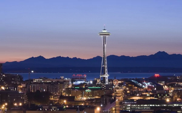HD desktop wallpaper featuring the illuminated Space Needle and Seattle cityscape at dusk with mountains in the background and a colorful evening sky in the USA.
