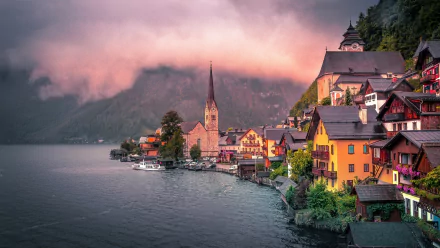 Foggy morning over the peaceful lakeside village of Hallstatt, Austria, showcasing colorful houses and a church steeple by the calm lake in 4K Ultra HD detail.