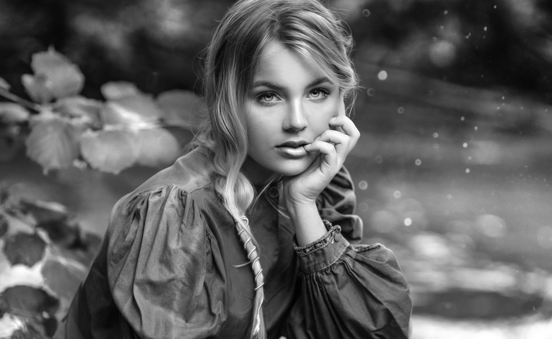 Black and white HD desktop wallpaper featuring a female model with soft depth of field, highlighting her contemplative expression and detailed textured clothing.