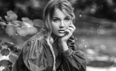 Black and white HD desktop wallpaper featuring a female model with soft depth of field, highlighting her contemplative expression and detailed textured clothing.