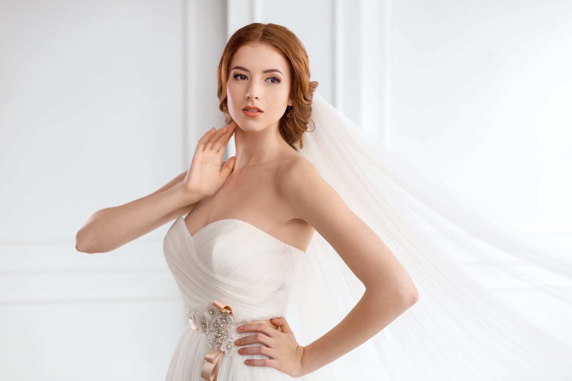 A redhead bride with brown eyes wearing a white wedding dress, posing gracefully in a bright setting, captured in 4K Ultra HD for PC desktop wallpaper.