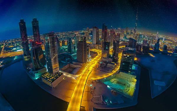 Fisheye aerial night cityscape of Dubai, United Arab Emirates, vibrant man-made skyline and illuminated roads in an HD desktop wallpaper background.