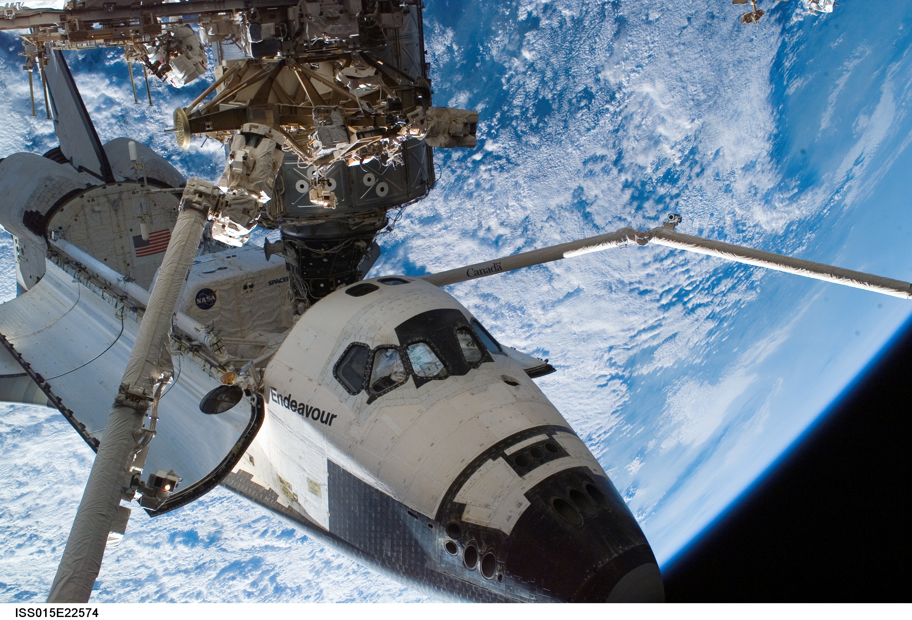 NASA HD desktop wallpaper of space shuttle and satellite captured from space, showing Earth.