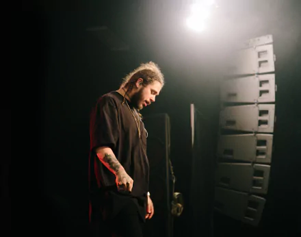 HD desktop wallpaper featuring a man standing on stage with a thoughtful expression, surrounded by stage equipment.