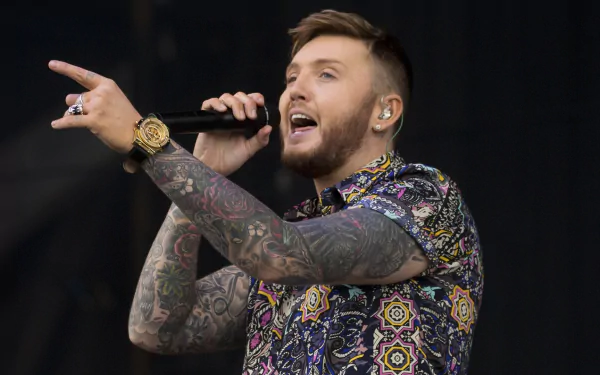 HD wallpaper featuring a man with tattoos performing, suitable as a vibrant desktop background.