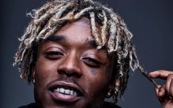 HD desktop wallpaper and background featuring a close-up of a person with blond dreadlocks and sparkling teeth jewelry.