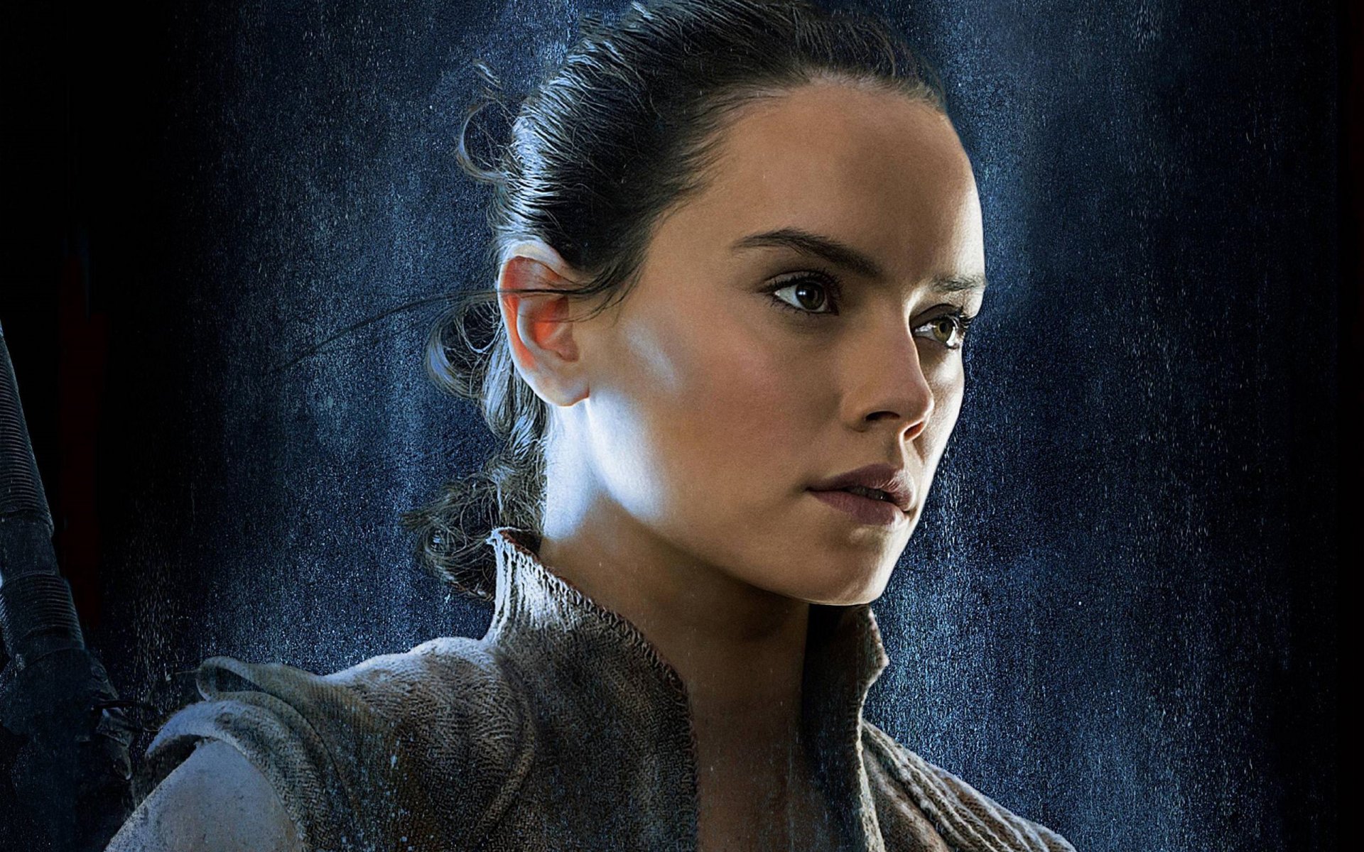 HD desktop wallpaper of Daisy Ridley as Rey from Star Wars: The Last Jedi. Rey appears in Jedi attire with a determined expression, against a misty blue background.
