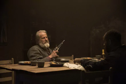 HD desktop wallpaper from Godless showing two characters in a dramatic, dimly-lit scene, one holding a gun at a table.