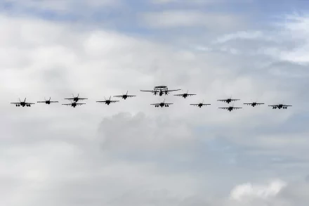 HD PC desktop wallpaper showing a formation of military jet fighters and warplanes flying together during an air show against a cloudy sky background.